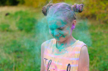 Painted portrait of young girl. Face with holi paint