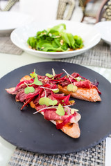 Bruschetta with ham rests on the plate.