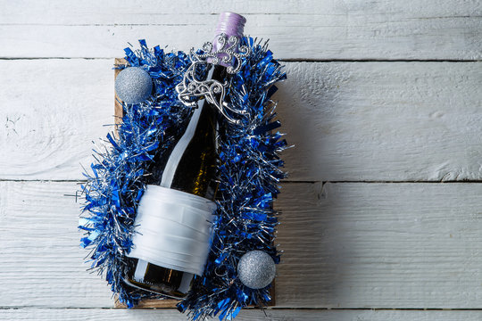 Photo of bottle of wine with blank card in box with tinsel,