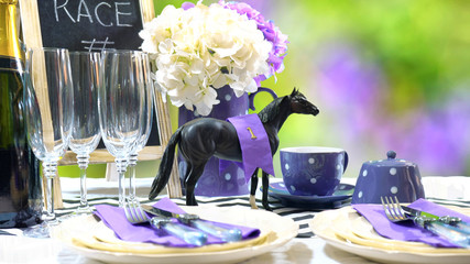 Horse racing Racing Day Luncheon fine dining table setting with small black fascinator hat, decorations and champagne, with copy space.