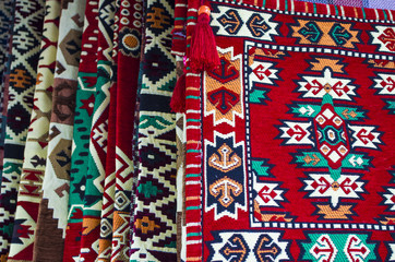 pile of turkish kilims as a colorful background handmade woven rugs and tapestry vintage carpets - obrazy, fototapety, plakaty