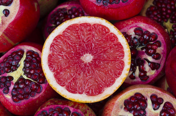 pile of fresh grapefruits on pomegranates background