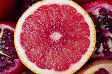 pile of fresh grapefruits on pomegranates background