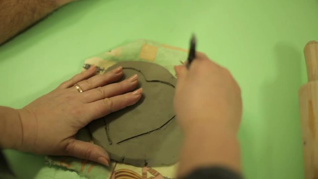 Master with students makes souvenirs from clay. Work process in an art workshop, work with clay. The master unrolls the clay. body parts