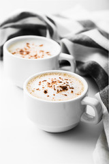 Two cappuccino on a white table. Morning coffee.