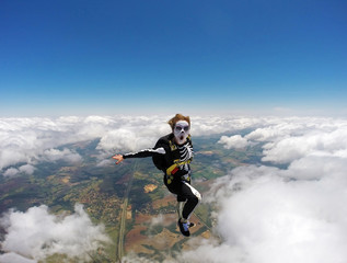 Naklejka na ściany i meble Woman costumed skeleton in free fall. Skydiving Happy Halloween.
