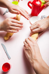 Close up, mother and child daughter preparing the dough, bake cookies. Child's hands baking Christmas gingerbread cookies.