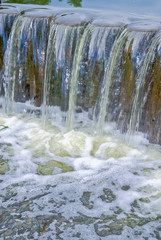 Decorative designed dam on a small river in the form of a waterfall