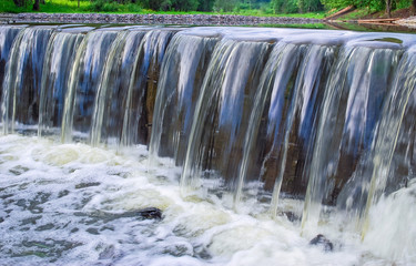Decorative designed dam on a small river in the form of a waterfall
