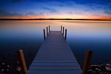 Relaxing view of dock going out onto Torch lake in northern Michigan - Powered by Adobe