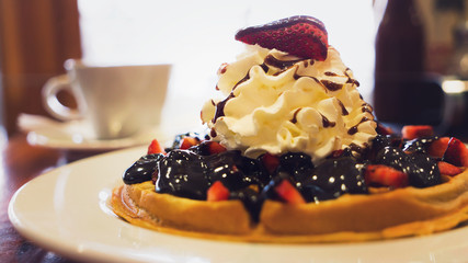 Delicious homemade waffle desert with fruits and whip creame