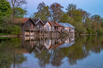 Fototapeta na wymiar Fishermans's hut in a row with reflections
