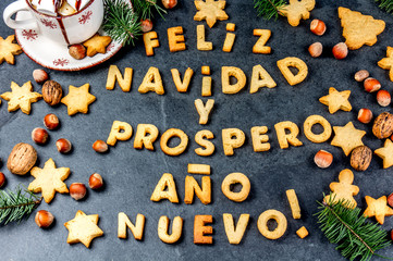 FELIZ NAVIDAD EN SPANISH COOKIES. Words Merry Christmas and happy new year en Spanish with baked cookies, Christmas card for hispanic countries top view