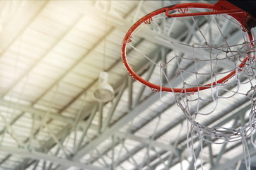 old orange basketball hoop with white net in indoor gymnasium sport background