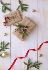 Christmas gift boxes and fir tree branch on wooden table, flat lay. Сhristmas background
