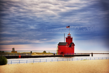 Beautiful red lighthouse on the beach of Michigan lake