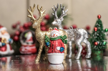 Small Christmas ornaments arranged into a holiday festive scene
