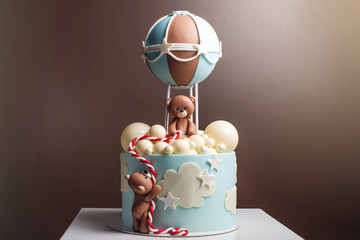Beautiful decorative cake for a child. Bears fly in a balloon. Concept of desserts for birthday