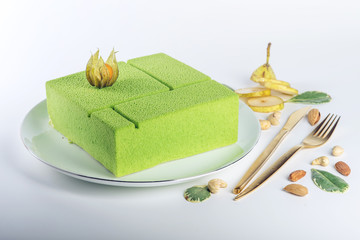Beautiful green cake with a filling of pears and cashews. Concept design desserts