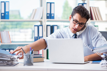 Businessman with excessive work paperwork working in office