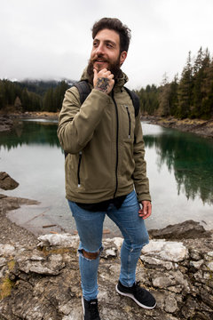 Hipster Adventurer hikes along Lake Obernberg in the mountains of Austria