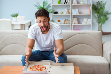 Man eating pizza having a takeaway at home relaxing resting