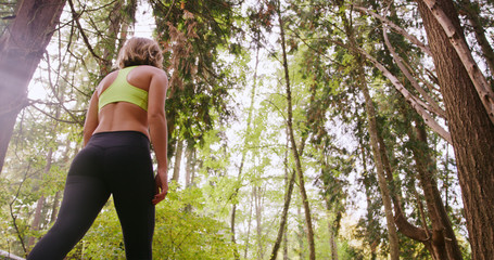 Runner Woman In Woods Exercising Outdoors Resting under trees