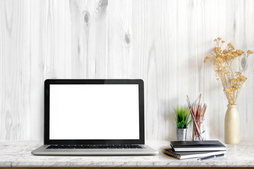 Stylish workspace with laptop computer, office supplies, houseplant and books at home or studio. Blank screen for graphics display montage.