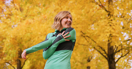 Fototapeta na wymiar Runner Woman In park Exercising Outdoors stretching
