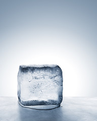 Summer heat relief, frosty cold blue ice block melting on scratched steel surface