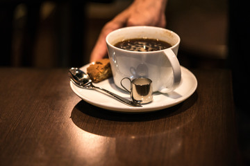 コーヒーを運ぶ店員