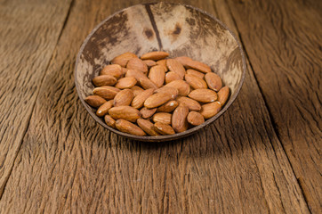 almond in wooden bowl on wooden board