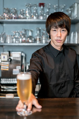 ビールを差し出すバーテンダー