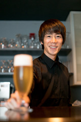 ビールを差し出すバーテンダー