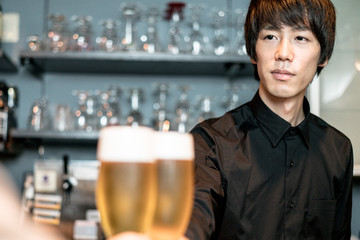 客と乾杯するバーテンダー