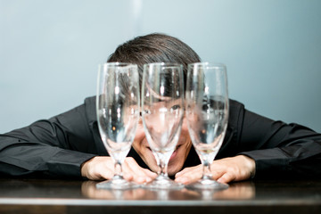 飲み干したグラス越しの男性