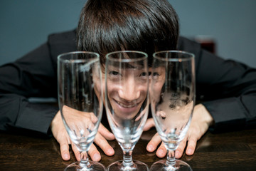 飲み干したグラス越しの男性