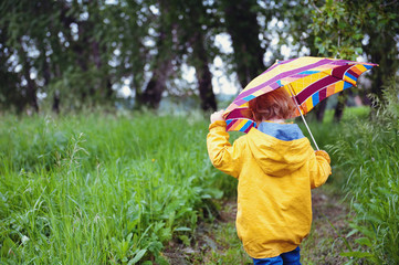 Child under an umbrella.