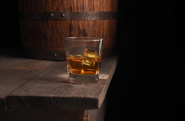 Glass of whiskey on rustic table.black background