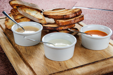 Slice of toast roasted in breaded with cheese and sesame slipped in a sauce on a wooden board