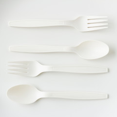 spoon and fork on grey background in top view
