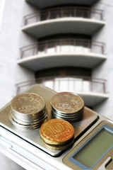 The facade of a residential high-rise house and coins.