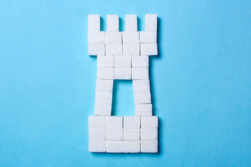 Sugar Castle from cubes of sugar on a blue background © adragan