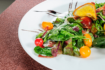 Green salad topped with yellow tomatoes.Top view