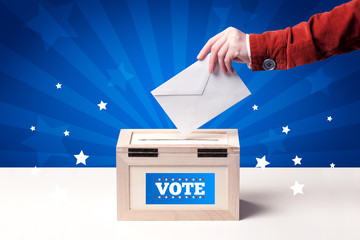 hand with ballot and wooden box
