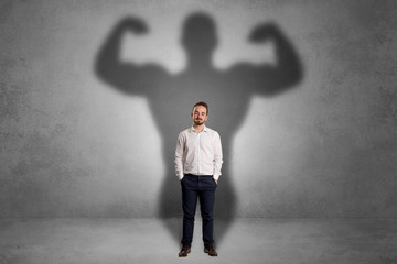 Businessman with muscular shade behind his back
