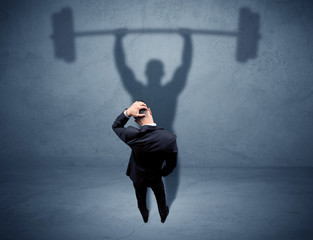 Businessman with weight lifting shadow