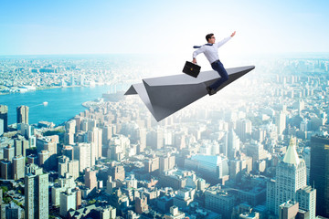 Fototapeta na wymiar Businessman flying on paper plane in business concept