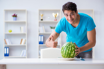 Man eating watermelon at home