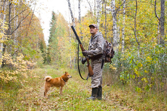 hunter with hunting gun in the autumn forest